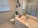 Well-lit bathroom featuring a floral shower curtain, decorative mirrors, and a tiled floor at 115 Turner St, Lincolnton, NC 28092