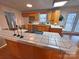 Eat-in kitchen features wood cabinets and a breakfast bar with tile countertops at 115 Turner St, Lincolnton, NC 28092