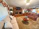 Inviting living room featuring a brick fireplace, hardwood floors, and access to the kitchen at 115 Turner St, Lincolnton, NC 28092