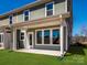 A backyard view of a new construction home, showing a concrete patio and verdant lawn space at 145 Halite Way, Waxhaw, NC 28173