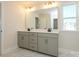 Neutral bathroom boasts double sink vanity, undermount sink, and a wide mirror at 145 Halite Way, Waxhaw, NC 28173