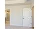 Carpeted bedroom with tray ceilings, neutral walls, and door leading to the bathroom with glass shower at 145 Halite Way, Waxhaw, NC 28173
