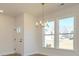 Bright dining room boasting wood-look floors, large windows, and a modern chandelier at 145 Halite Way, Waxhaw, NC 28173