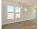 Bright dining room boasting wood-look floors, large windows, and a modern chandelier at 145 Halite Way, Waxhaw, NC 28173