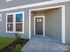 Charming covered entrance with a gray front door, complemented by a window allowing natural light into the foyer at 145 Halite Way, Waxhaw, NC 28173