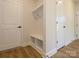Mud room and hallway area with neutral paint, hardwood floors and built-in bench with storage cubbies at 145 Halite Way, Waxhaw, NC 28173