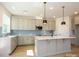 Well-lit kitchen featuring stainless steel appliances, a large island and a stylish blue tile backsplash at 145 Halite Way, Waxhaw, NC 28173