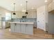Spacious kitchen featuring gray cabinets, stainless steel appliances, a center island, and modern pendant lighting at 145 Halite Way, Waxhaw, NC 28173