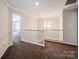 Carpeted hallway with a chandelier and access to multiple rooms at 107 Monterey Dr, Mooresville, NC 28117
