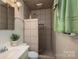 Tiled bathroom featuring walk-in shower with pebble floor and vintage faucet at 3092 Lee Lawing Rd, Lincolnton, NC 28092