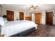 Bedroom with hardwood floors, white bedding, and multiple wooden doors and storage spaces at 3092 Lee Lawing Rd, Lincolnton, NC 28092