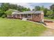 Inviting brick home with well-kept lawn, charming front porch, and landscaped garden beds at 3092 Lee Lawing Rd, Lincolnton, NC 28092