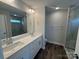 Modern bathroom with double sinks, white cabinets, quartz countertop and a glass-enclosed shower at 6259 Tea Olive Dr # 178, Harrisburg, NC 28075