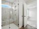 Modern bathroom featuring a marble tiled shower with glass door and a window, plus views into the bedroom at 6259 Tea Olive Dr # 178, Harrisburg, NC 28075