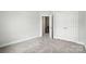 Neutral carpeted bedroom featuring a closet and an entrance to a staircase at 6259 Tea Olive Dr # 178, Harrisburg, NC 28075