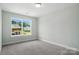 Bright bedroom with neutral carpet and large window overlooking the street view at 6259 Tea Olive Dr # 178, Harrisburg, NC 28075