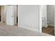 Well-lit hallway leading to additional rooms, highlighting neutral carpet and white doors at 6259 Tea Olive Dr # 178, Harrisburg, NC 28075