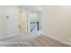 A bright hallway featuring a staircase with dark wood railing and carpeted floors for comfortable transition between levels at 6259 Tea Olive Dr # 178, Harrisburg, NC 28075