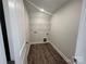 Functional laundry room with wood-look flooring, overhead light and wire shelving at 6259 Tea Olive Dr # 178, Harrisburg, NC 28075