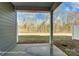 Covered outdoor patio area with a view of the wooded backyard and a concrete floor at 6259 Tea Olive Dr # 178, Harrisburg, NC 28075