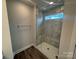 Shower featuring glass doors, chrome hardware, and tiled walls with a marble-like pattern at 6259 Tea Olive Dr # 178, Harrisburg, NC 28075