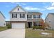 Charming two-story home with brick and siding, well-manicured lawn, and attached two-car garage at 7618 Fenn Way, Indian Land, SC 29707