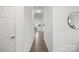 Bright hallway with wood-look flooring, white walls, and a view towards the living areas at 7618 Fenn Way, Indian Land, SC 29707