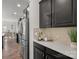 Well-lit kitchen with stainless steel appliances, mosaic backsplash, and dark cabinetry at 7618 Fenn Way, Indian Land, SC 29707