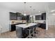 Modern kitchen with dark cabinets, white countertops, stylish pendant lighting, and bar stool seating at the island at 7618 Fenn Way, Indian Land, SC 29707