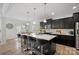 Bright kitchen featuring dark cabinets, an island with bar stools, and a view to the dining area at 7618 Fenn Way, Indian Land, SC 29707