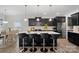 Open kitchen with dark cabinets, center island with seating, and adjacent dining area at 7618 Fenn Way, Indian Land, SC 29707