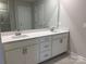 Double vanity bathroom with white cabinets and a large mirror at 106 Obadiah Ct, Troutman, NC 28115
