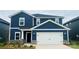 Charming two-story home with a blue exterior, white trim, stone accents, and a two-car garage at 106 Obadiah Ct, Troutman, NC 28115