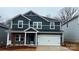 Charming two-story home with dark siding, white trim, and a two-car garage at 122 Satchel Ct, Troutman, NC 28115