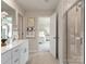 Bright bathroom with double vanity, white cabinets, tiled floors and a glass-enclosed shower at 122 Satchel Ct, Troutman, NC 28115