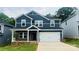 Charming two-story home with a two-car garage, dark blue siding, brick accents, and a well-manicured lawn at 122 Satchel Ct, Troutman, NC 28115