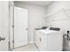 Laundry room with washer, dryer, storage shelves, and a door to another room at 122 Satchel Ct, Troutman, NC 28115