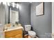 Stylish half bathroom with gray walls, modern sink and toilet, and decorative wall art at 3195 Hadden Hall Blvd, Fort Mill, SC 29715