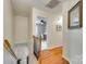 Upstairs hallway with hardwood floors leading to a bedroom and featuring a decorative mirror at 3195 Hadden Hall Blvd, Fort Mill, SC 29715