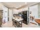 White cabinet kitchen with tile floor, gray island, stainless appliances and large black refrigerator at 3195 Hadden Hall Blvd, Fort Mill, SC 29715