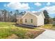 Exterior of a charming beige home featuring a covered front porch with wooden railings, with a freshly poured concrete driveway at 501 Ed Wilson Rd, Bessemer City, NC 28016