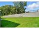 Large backyard with a retaining wall and newly installed lawn at 5112 Heathland Dr # 75, Charlotte, NC 28215