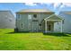 Exterior view of home, showing the backyard, covered patio, and green siding at 5112 Heathland Dr # 75, Charlotte, NC 28215
