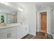 Bright bathroom features a double vanity, a large mirror and an open doorway to another room at 5112 Heathland Dr # 75, Charlotte, NC 28215