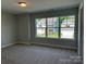 Bedroom featuring neutral carpet and a large window overlooking other homes at 5112 Heathland Dr # 75, Charlotte, NC 28215