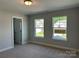 Bedroom featuring neutral carpet and two windows overlooking the front yard at 5112 Heathland Dr # 75, Charlotte, NC 28215