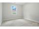 Bright bedroom with neutral carpet, large window and base molding at 5112 Heathland Dr # 75, Charlotte, NC 28215