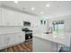 Bright, modern kitchen featuring an island with stainless steel appliances, white cabinets, and backyard views at 5112 Heathland Dr # 75, Charlotte, NC 28215