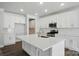 Bright kitchen features white cabinets, stainless steel appliances, a large island, and recessed lighting at 5112 Heathland Dr # 75, Charlotte, NC 28215