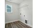 Clean laundry room featuring vinyl floors, modern shelving, and a small window at 5112 Heathland Dr # 75, Charlotte, NC 28215
